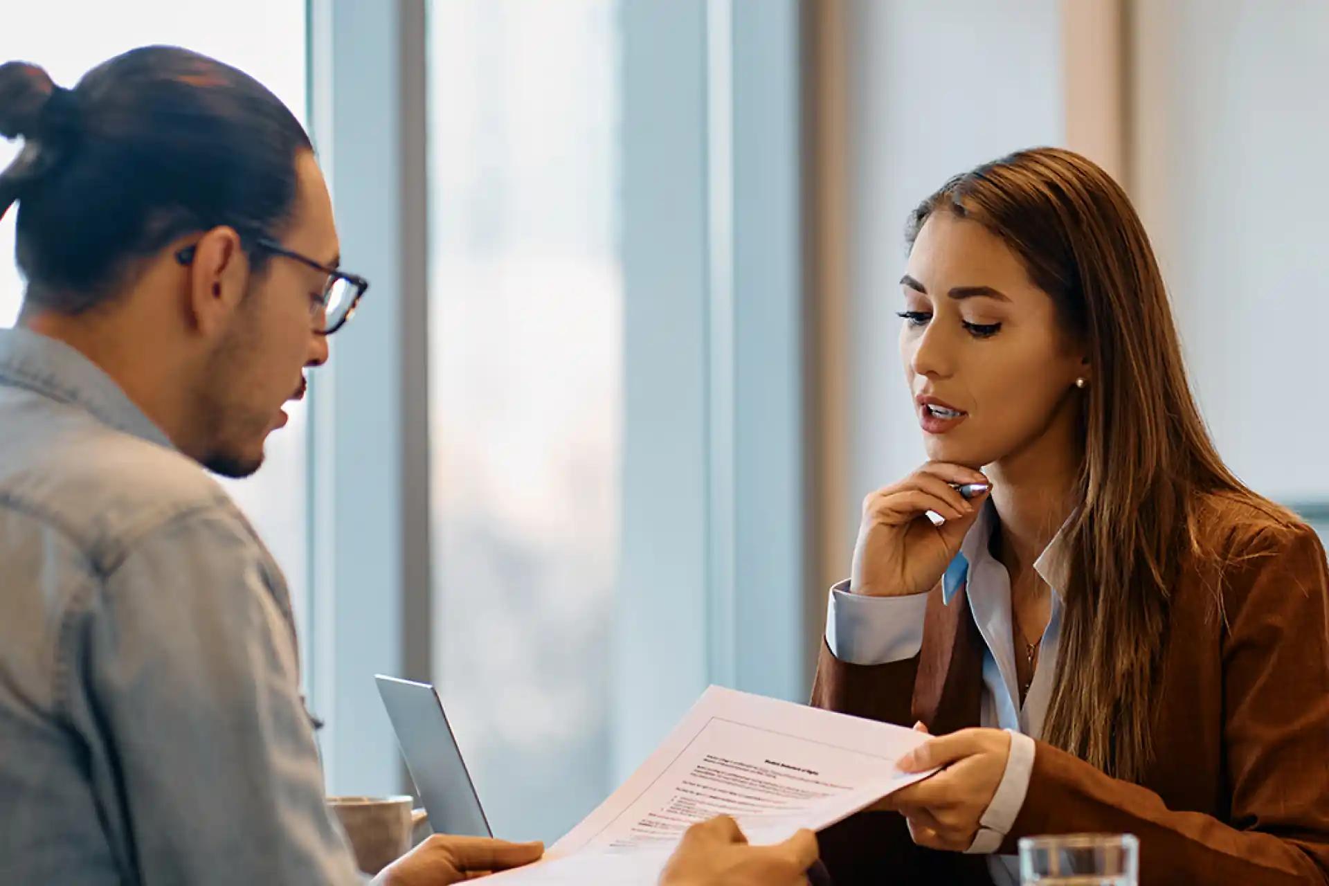 Two professionals reviewing a document during a meeting or interview